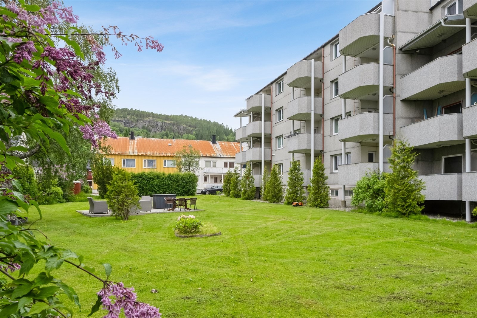 Fellesarealer er ryddig og pent opparbeidet med gressplen og diverse beplantning. Areal bak sittegruppe skal gjøres om til parkering for borettslag. Galleribilde
