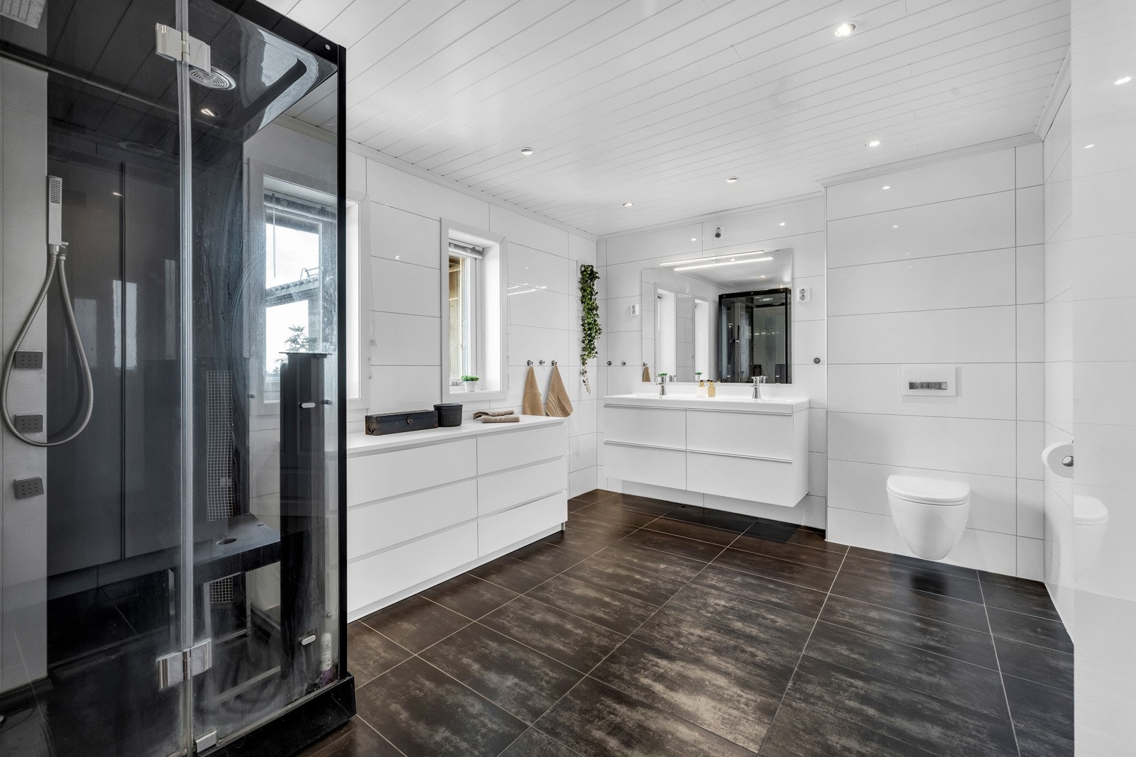 Badet har stilren innredning, spadusj og god plass til oppbevaringsmøblement. Galleribilde