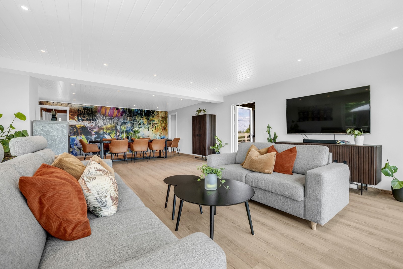 1. etasje har stor stue med plass til langbord i egen sone, og tilbaketrukket kjøkken i åpen løsning. Galleribilde