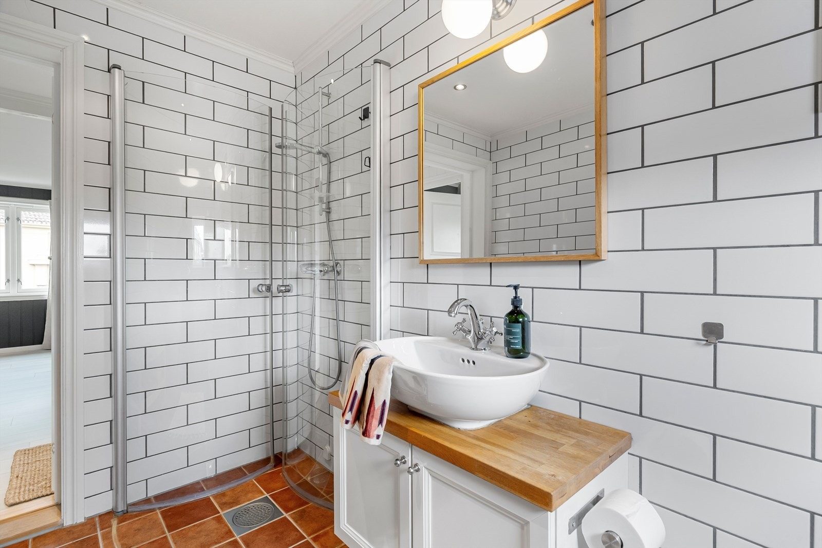 Vegghengt toalett er både praktisk og kledelig, og godt med plass for vaskemaskin og tørketrommel ved opplegget. Tidsriktig baderomsinnredning med servant med underskap. Galleribilde