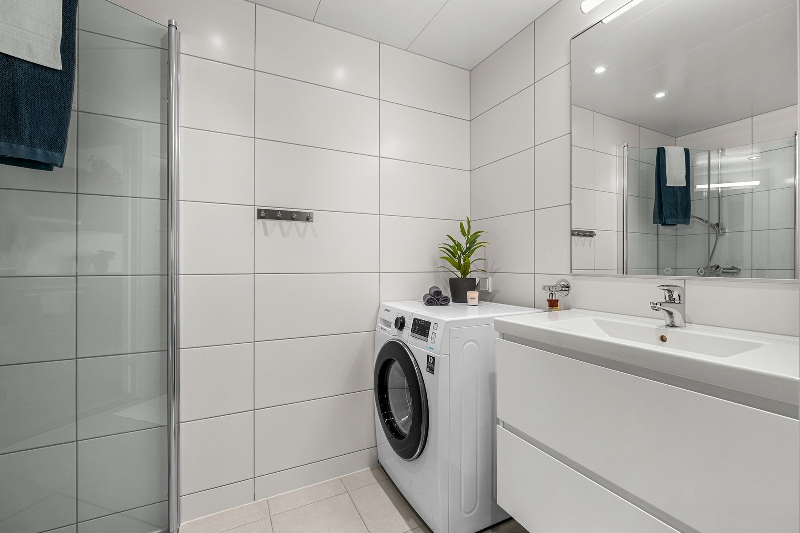 Badet er utstyrt med dusjhjørnet, opplegg til vaskemaskin og downlights i taket Galleribilde