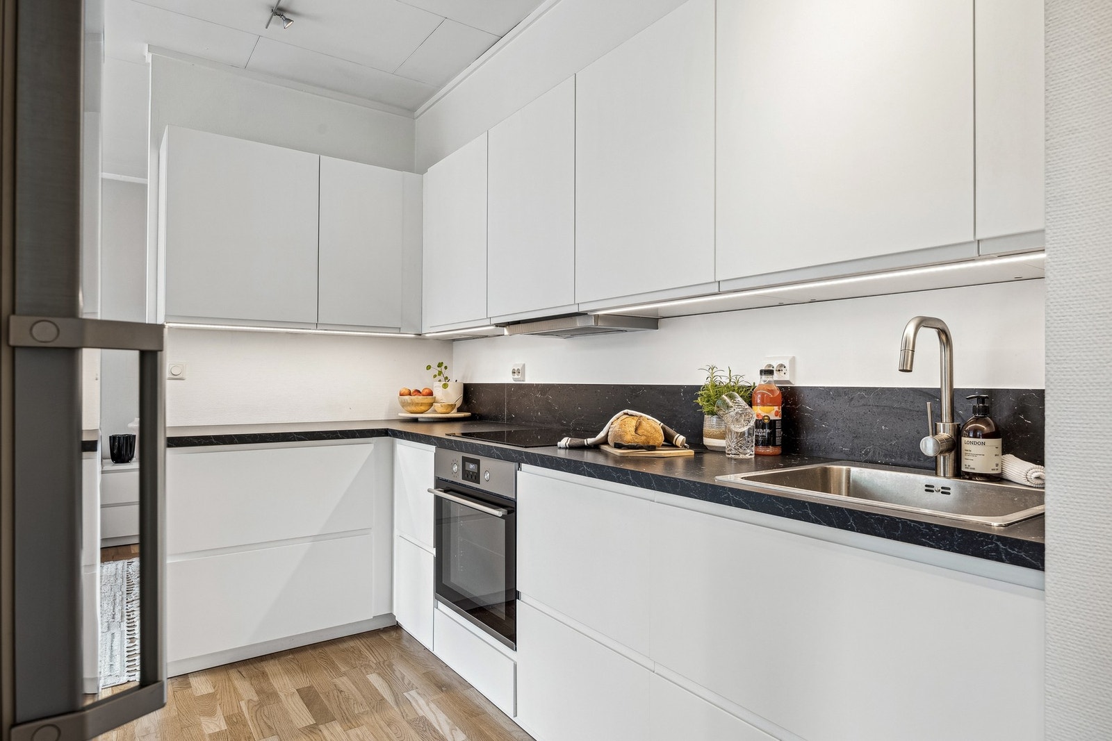 Kjøkkenet har glatte fronter og et moderne uttrykk, og passer godt inn i boligens helhetlige stil. Galleribilde