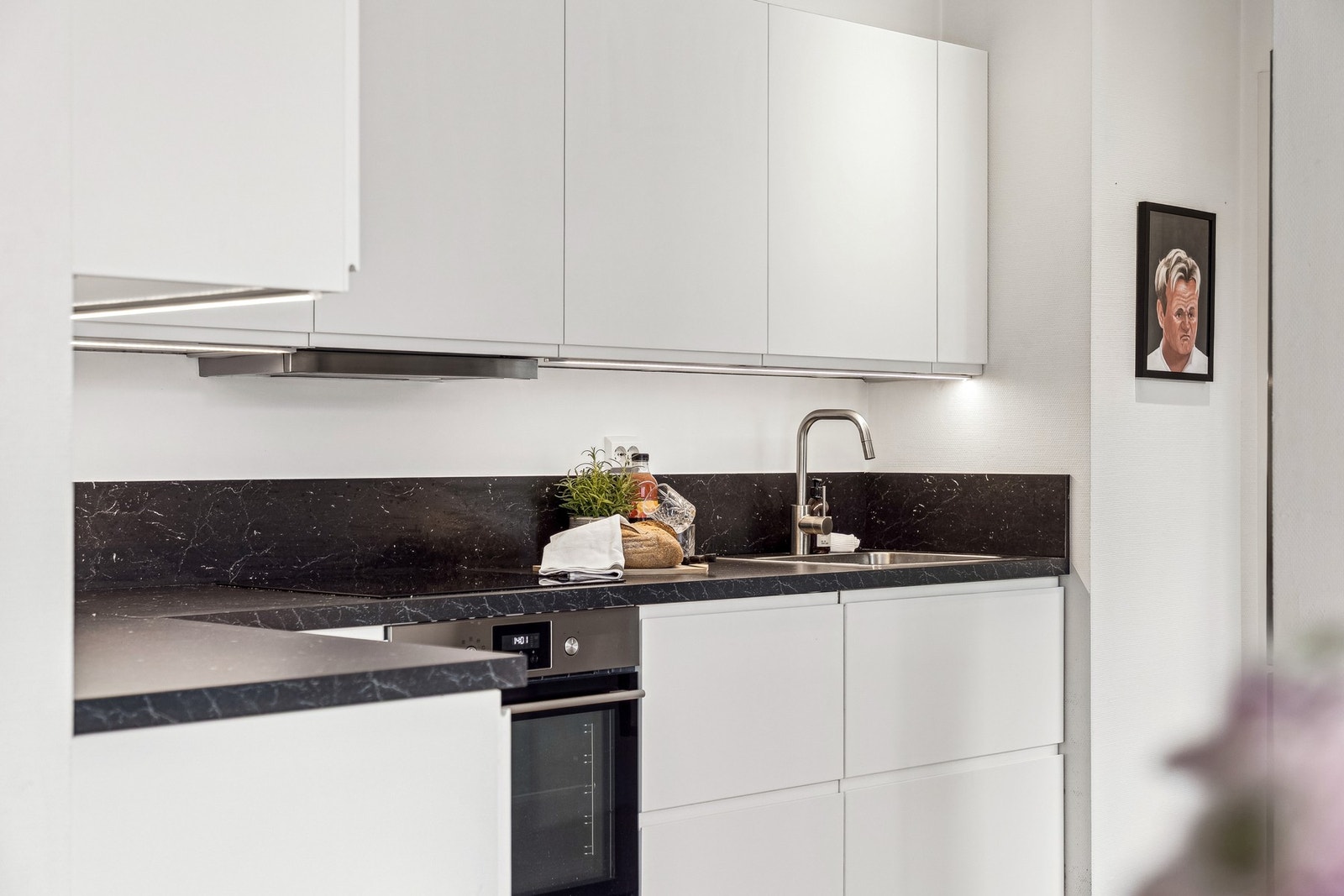 Kjøkkenet er utstyrt med en nedfelt oppvaskkum og et praktisk ett-greps armatur. Det er belysning under overskapene og stikkontakter plassert over benken - noe som gir gode arbeidsforhold. Galleribilde