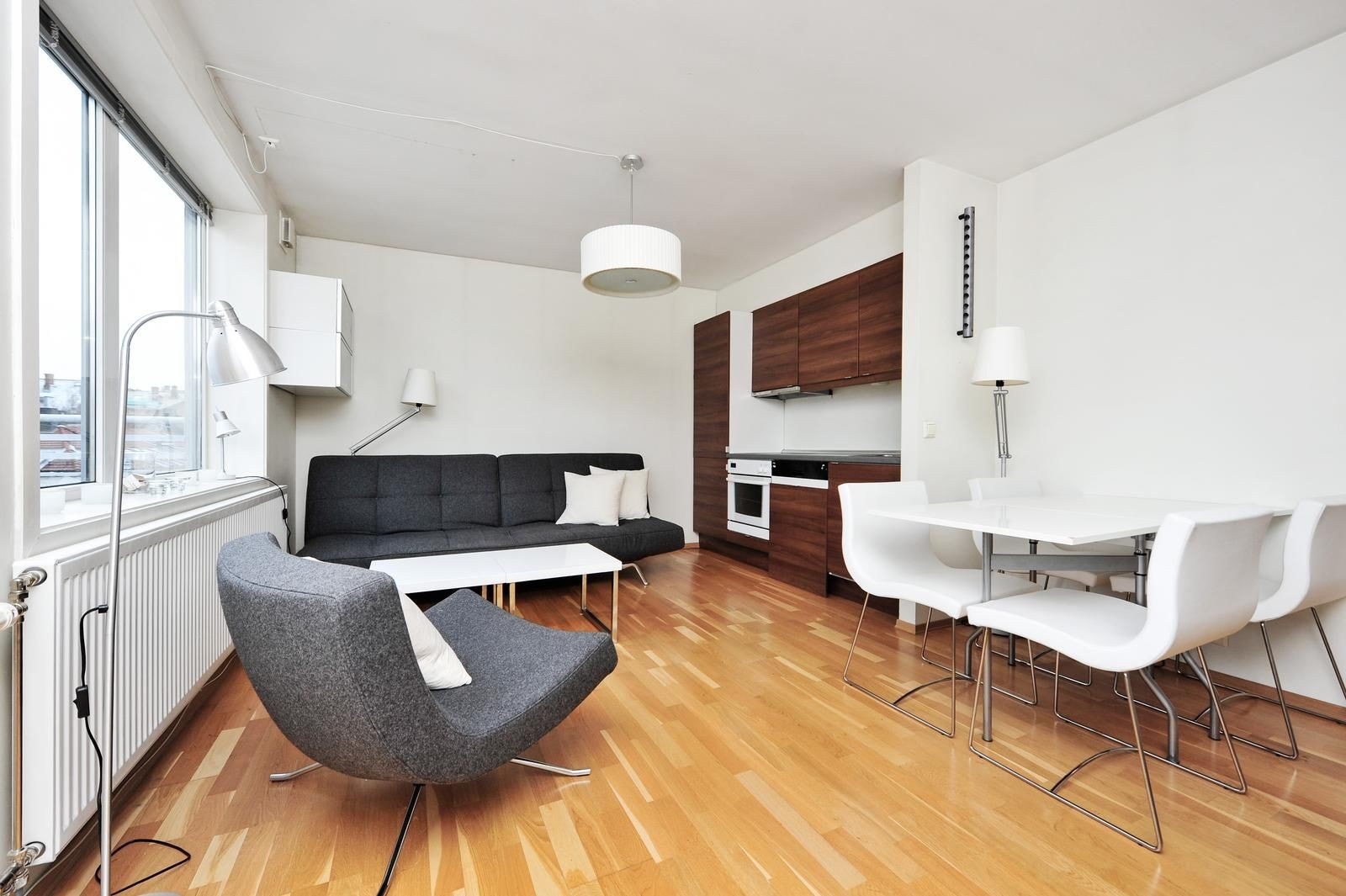 Stue med sofagruppe og spisebord. Åpen kjøkkenløsning med alle hvitevarer. Galleribilde