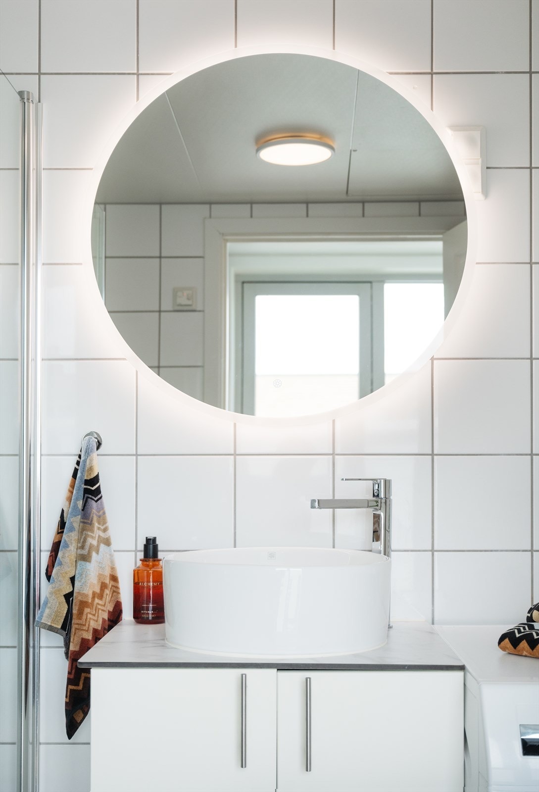 Baderomsinnredningen består av vegghengt toalett, servant, speil med belysning , dusjarmatur, dusjdører i glass og plass/opplegg for vaskemaskin. Galleribilde
