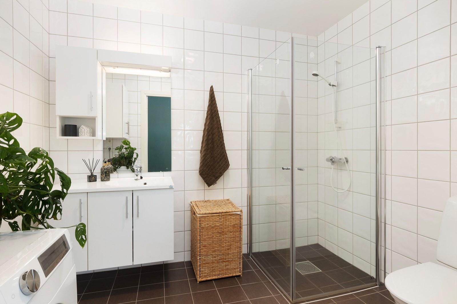 Tidlaust heilflisa bad med vannboren varme i golv. Badet er innreia med kvit baderomsinnreiing med slette frontar, dusjhjørne, toalett og har opplegg for vaskemaskin. Galleribilde