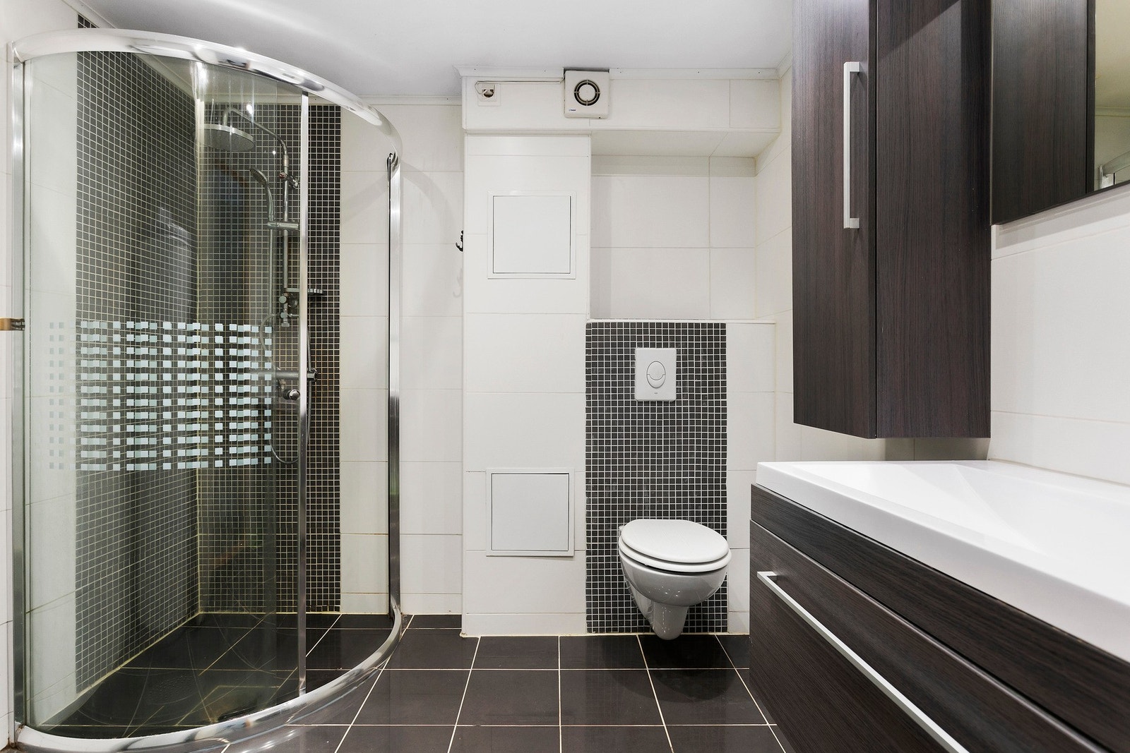 Stort bad med flislagte vegger og gulv med varme. Dusjhjørne med glassfelt og skyvedør av glass. Boligens varmtvannsbereder fra 2018 er også her Galleribilde