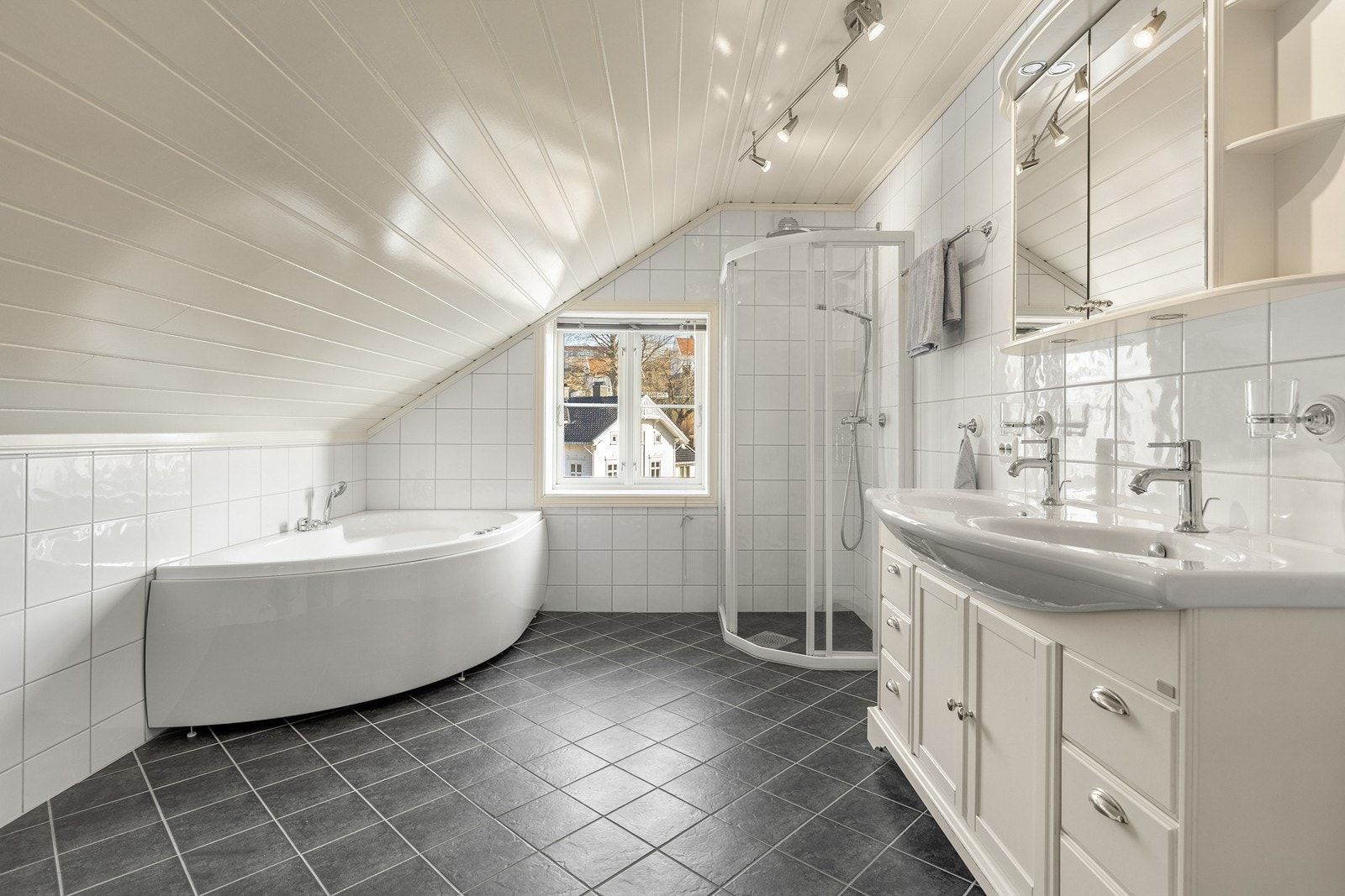 Badet i 2. etg. er romslig med boblebadekar, dusjhjørne, og baderomsinnredning med speilskap over Galleribilde