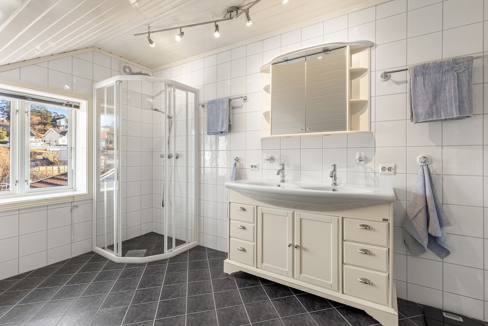 Badet er flislagt på gulv og vegger, med varmekabler i gulv Galleribilde