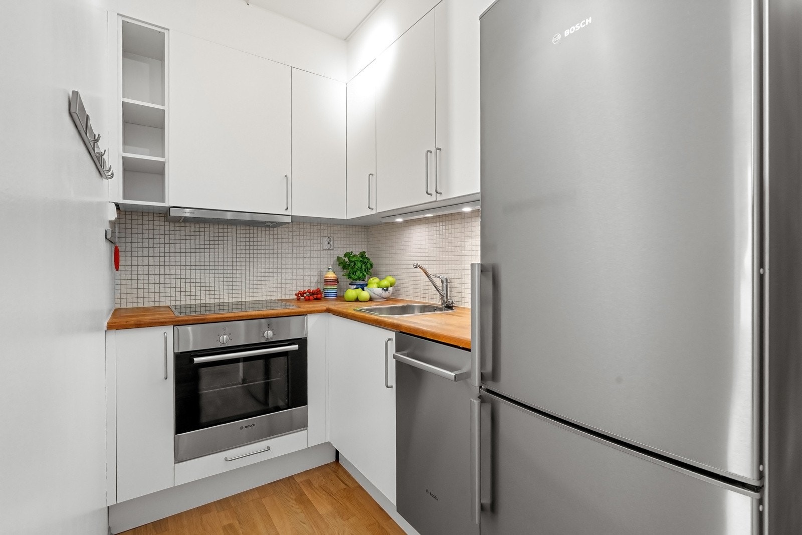 Kjøkkeninnredningen er fra Sigdal og har glatte, hvite fronter og benkeplate i heltre eik. Alle hvitevarer på kjøkken medfølger ved salg. Galleribilde