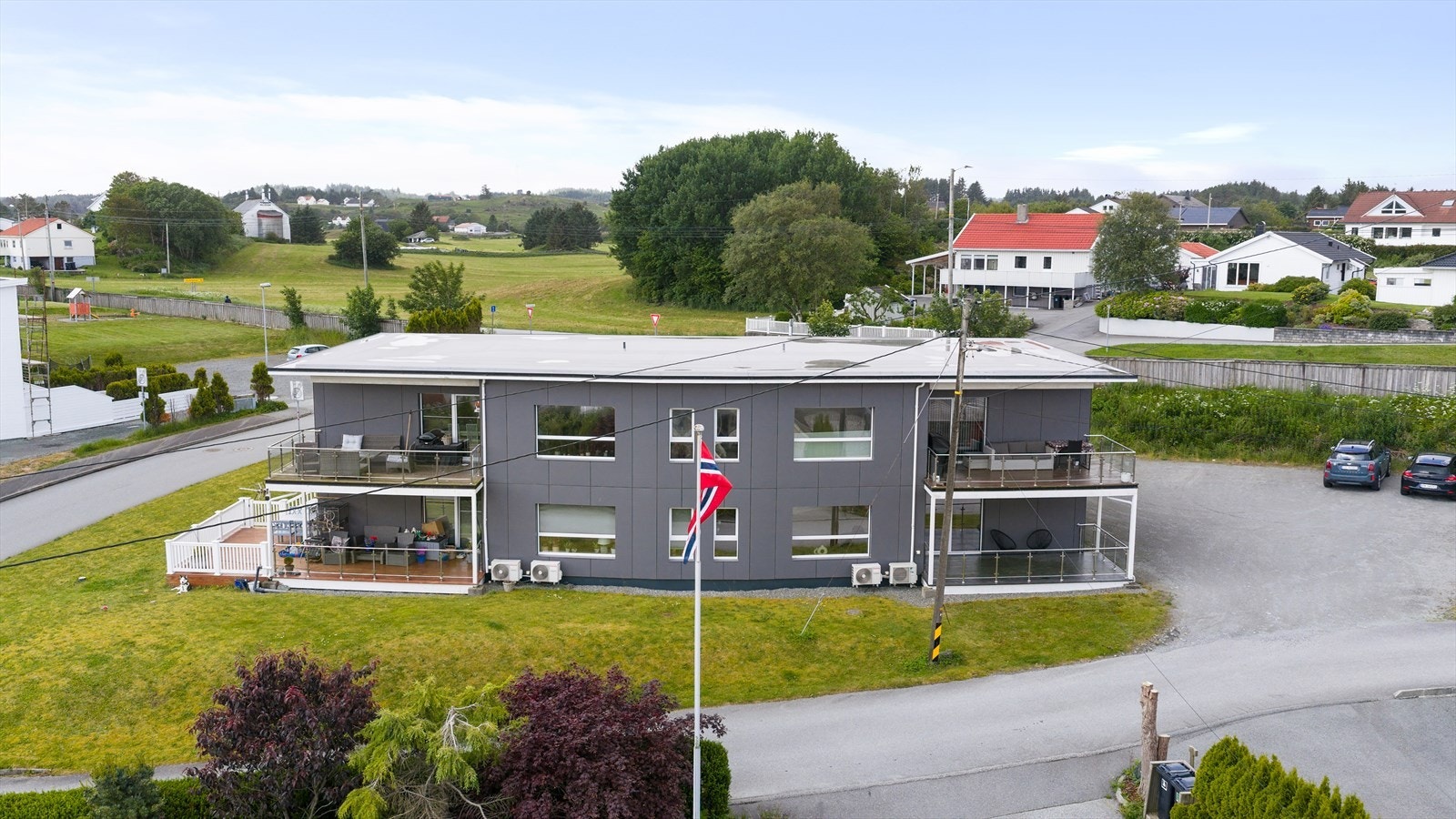 Sameiet har en felles eiet tomt som er opparbeidet med romslig gårdsplass og plen (gode parkeringsmuligheter samt lader for elbil på husveggen) Galleribilde
