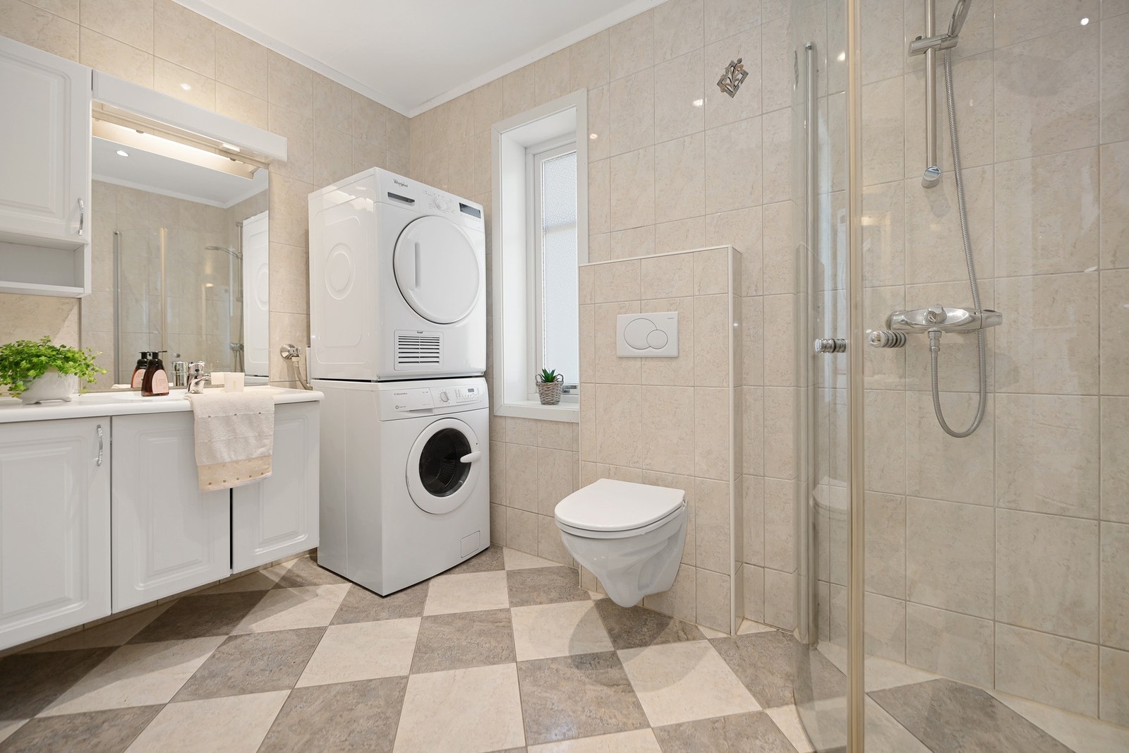 Flislagt bad i 1. etasje med dusjhjørne og moderne innredning. Galleribilde