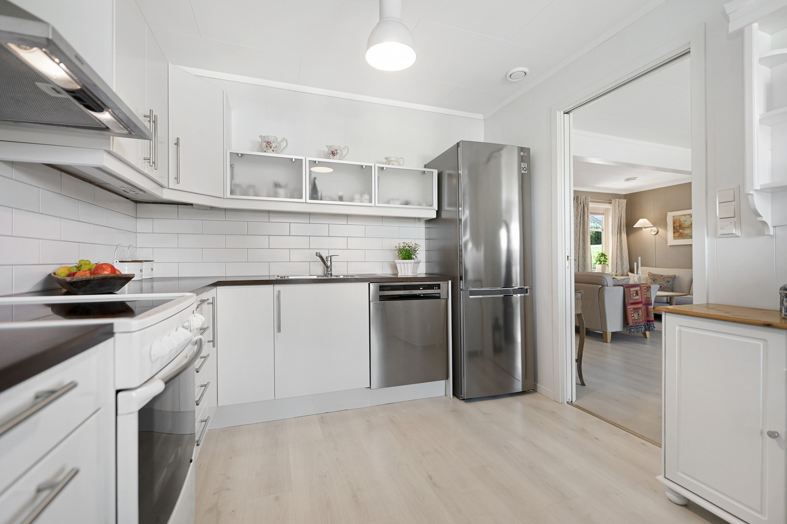 Tidløst kjøkken med hvite fronter og rikelig benkeplass. Galleribilde