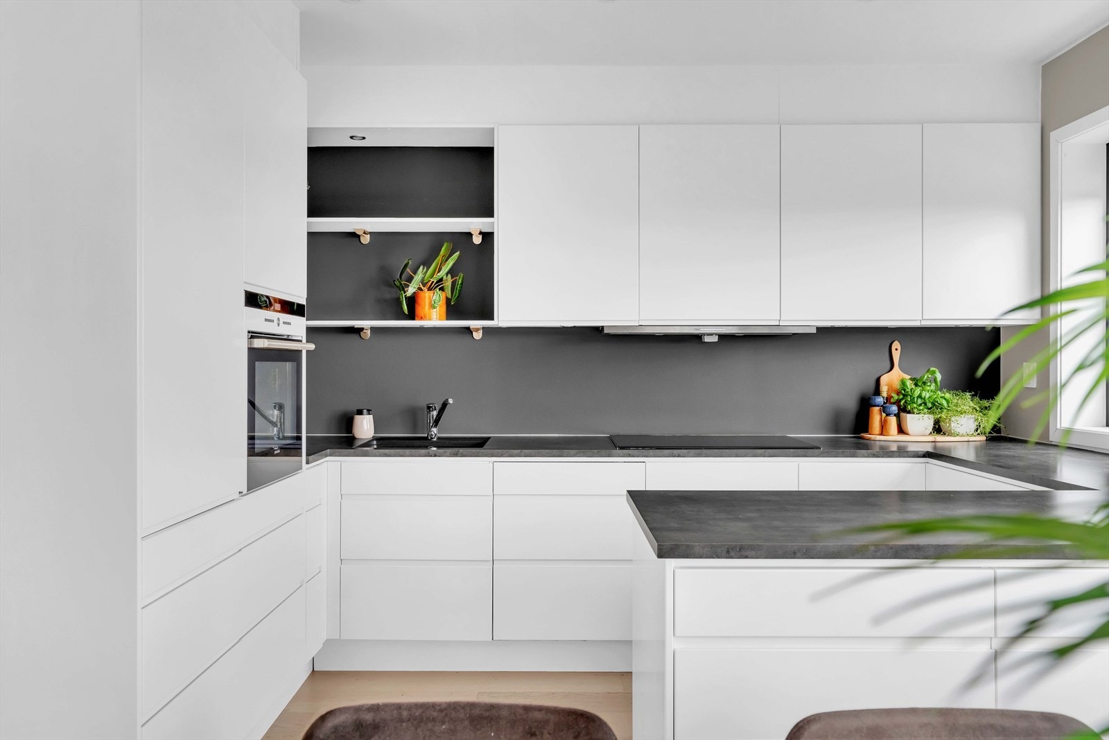 Veggen bak kjøkkenbenken er malt i sort, og står svært fint til den mørke benkeplaten. Galleribilde