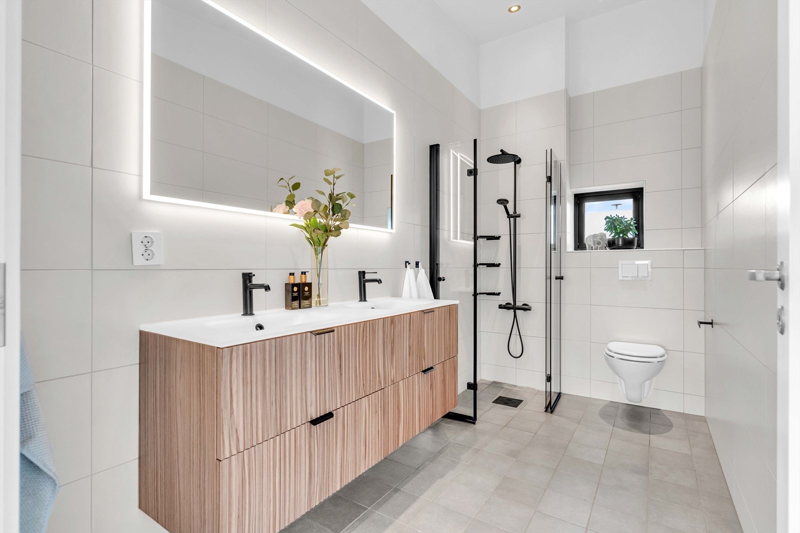 Videre er det satt inn dusjhjørne med glassdører og vegghengt toalett. Galleribilde