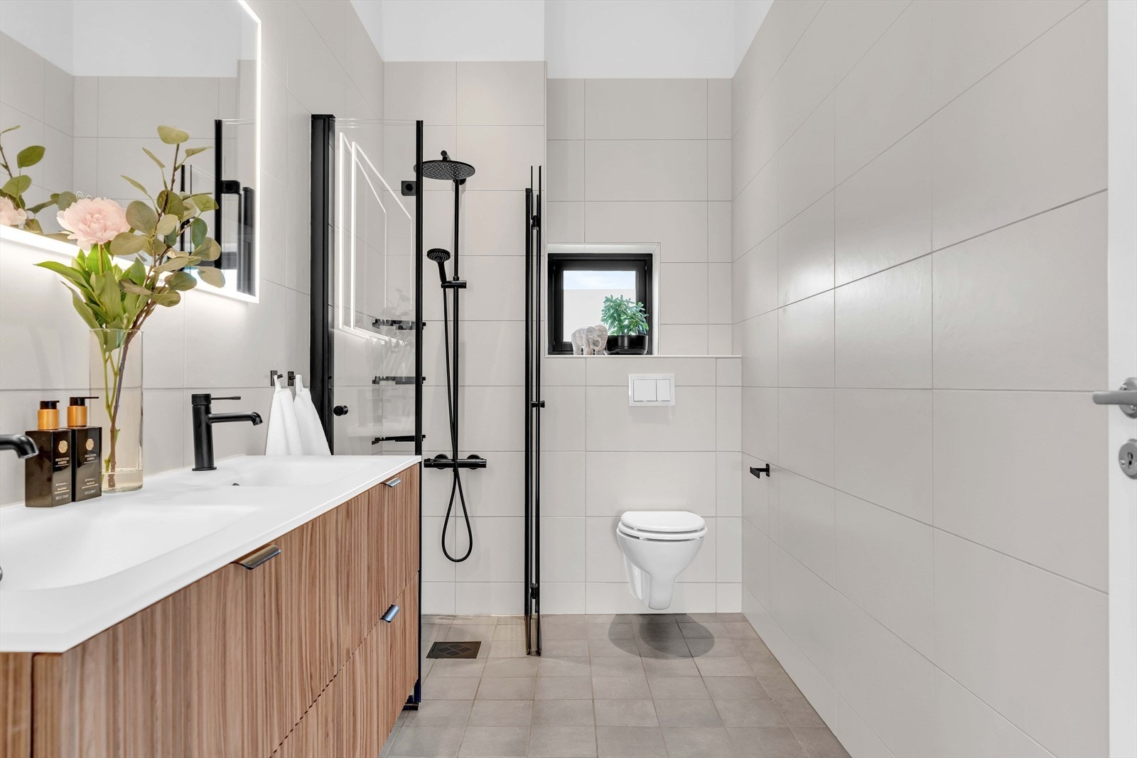 Etasjen har et lekkert flislagt baderom, innredet med servantskap med nedfelt dobbel servant, underskuffer og 1-greps blandebatteri. Galleribilde