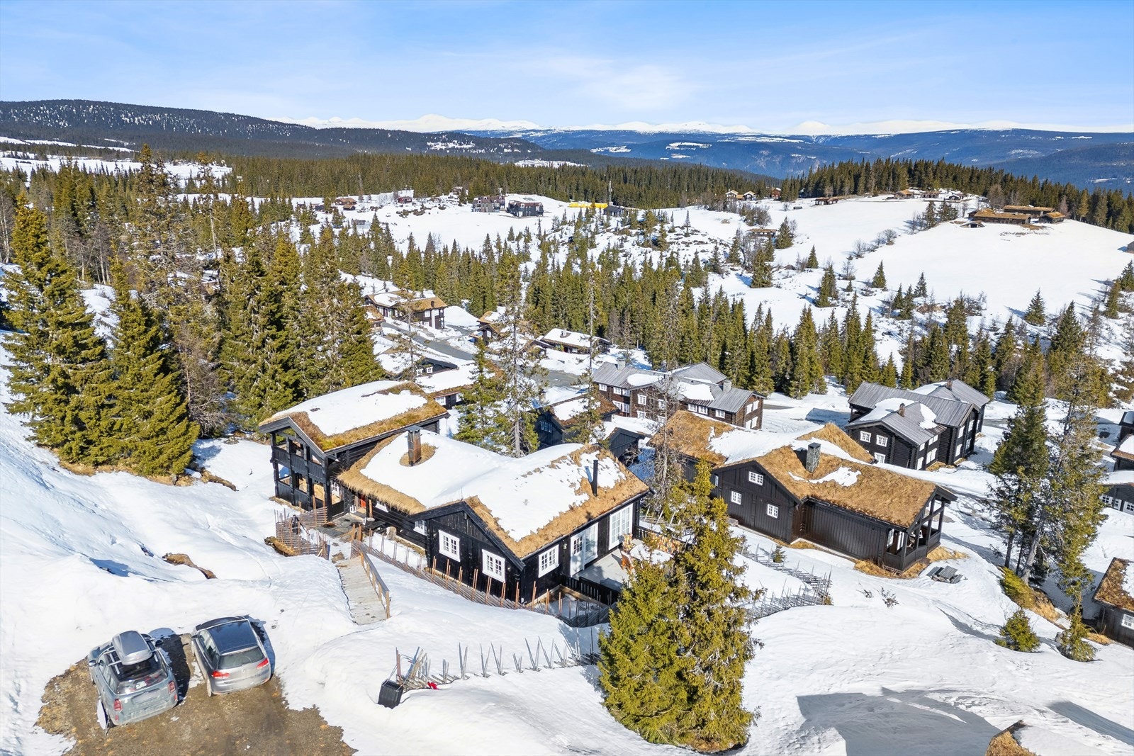 Plass til å parkere bilen på et høyere nivå, med trapp ned til hytta. Galleribilde