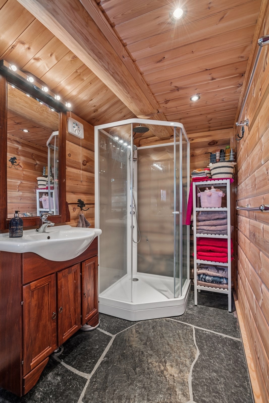 Badet er utstyrt med toalett, dusjhjørne og baderomsinnredning. Galleribilde