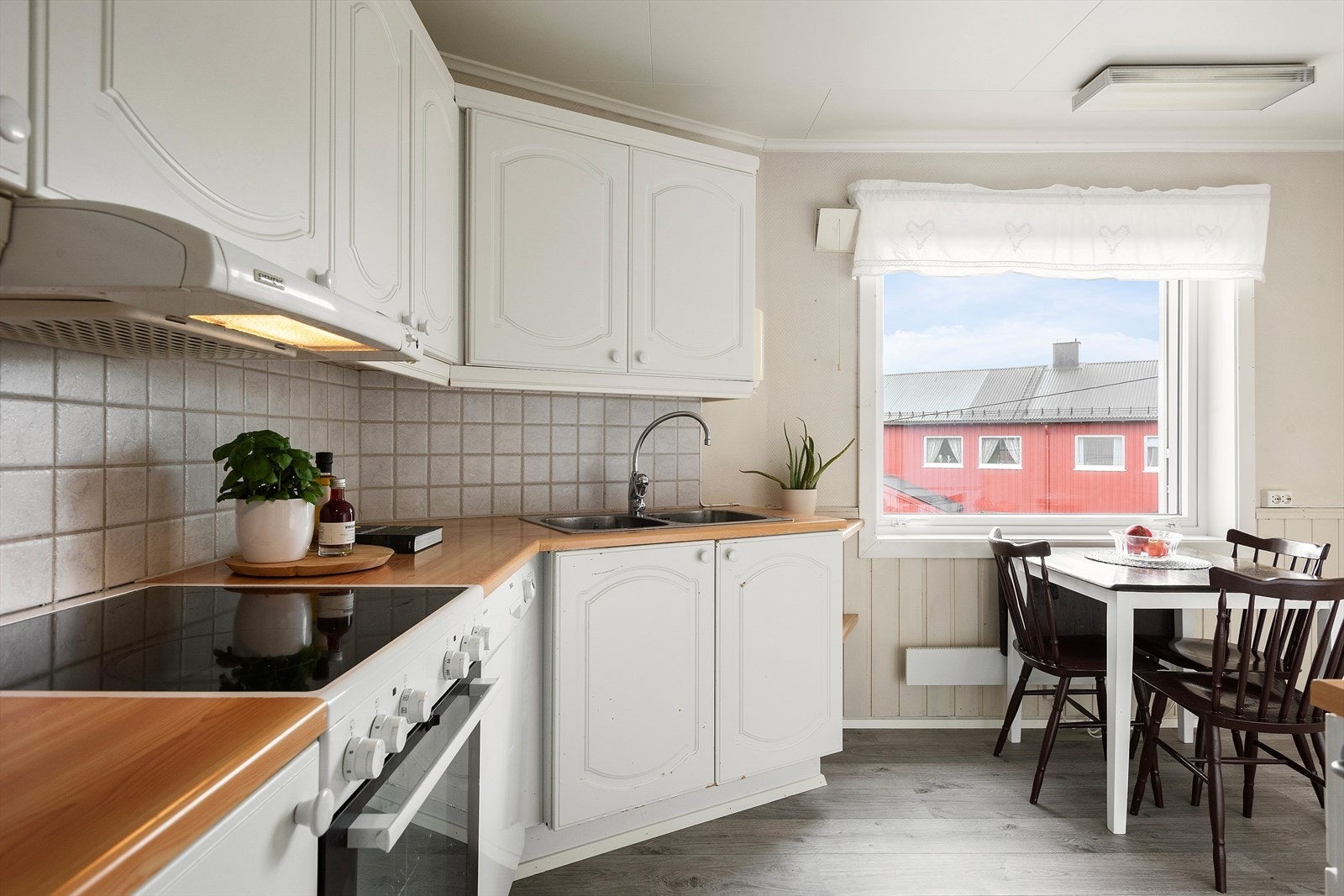 Kjøkkenet er utstyrt med profilerte fronter og en laminert benkeplate som gir et stilrent og funksjonelt preg. Galleribilde