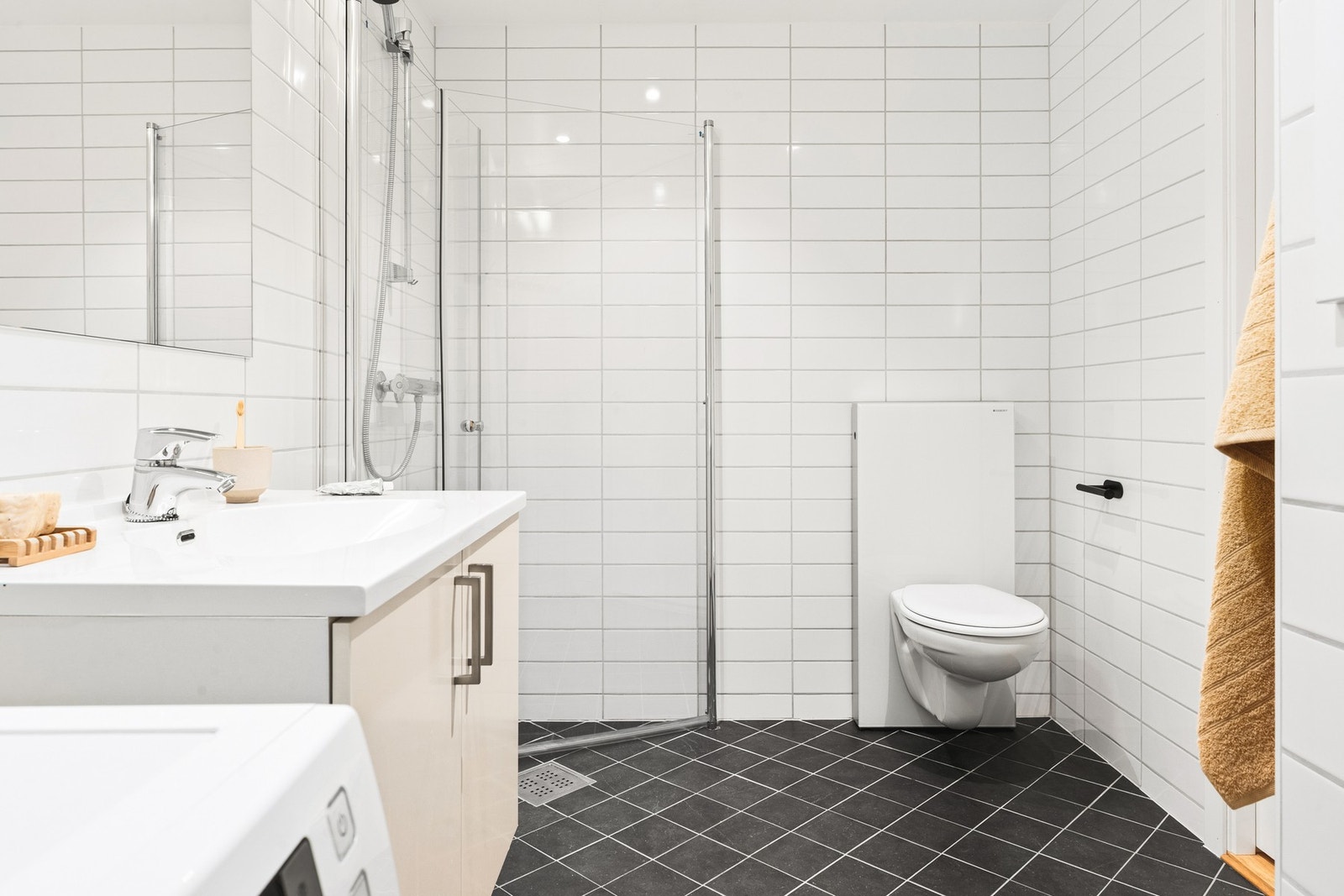 På badet er det vegghengt toalett, dusj med innfellbare dører og nyere servantmøbel med overhengende speil. Galleribilde