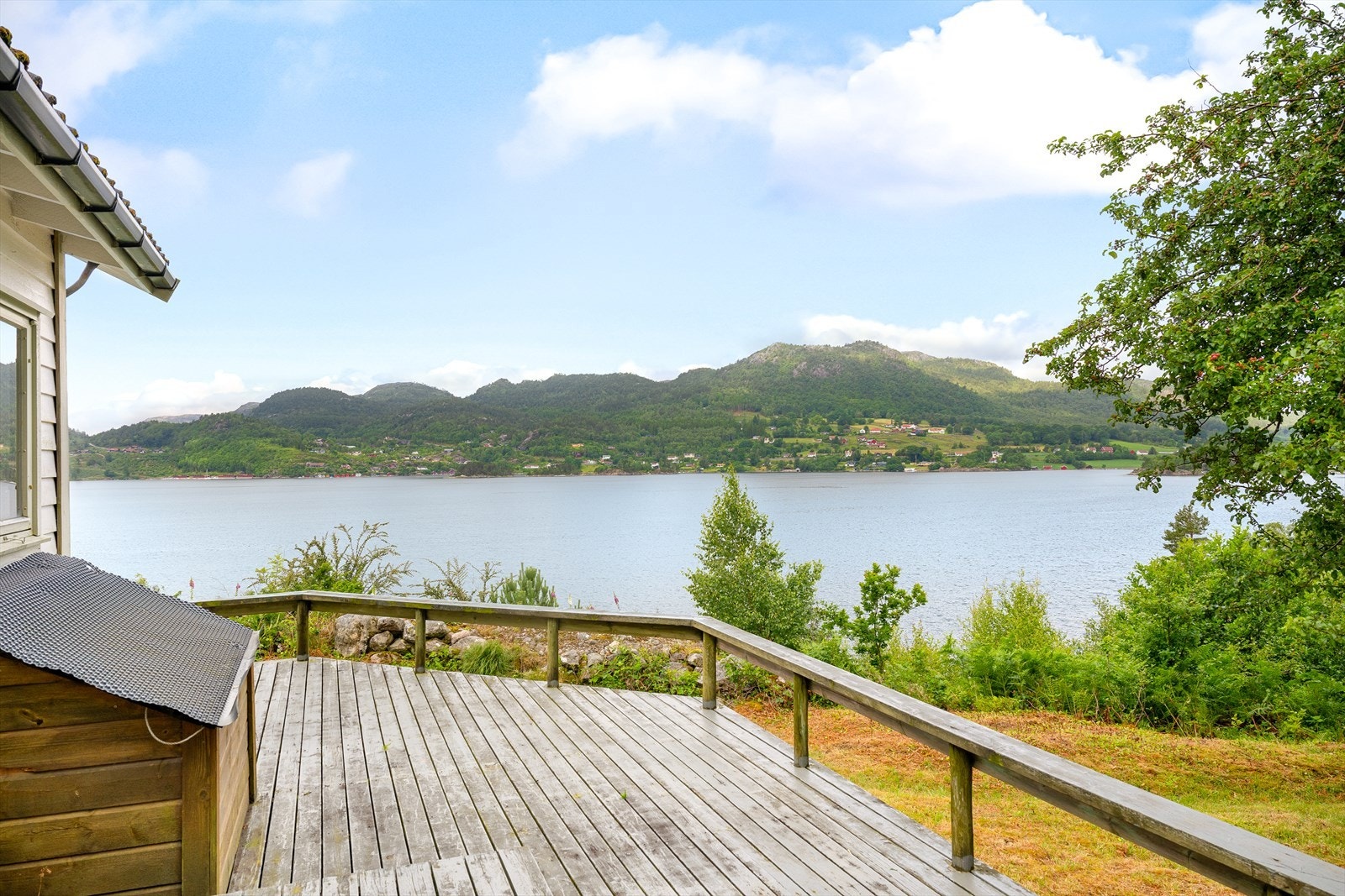 Eiendommen strekker seg til sjøen og hytta er plassert i høyden mot vest med sol hele dagen til sent på kvelden Galleribilde