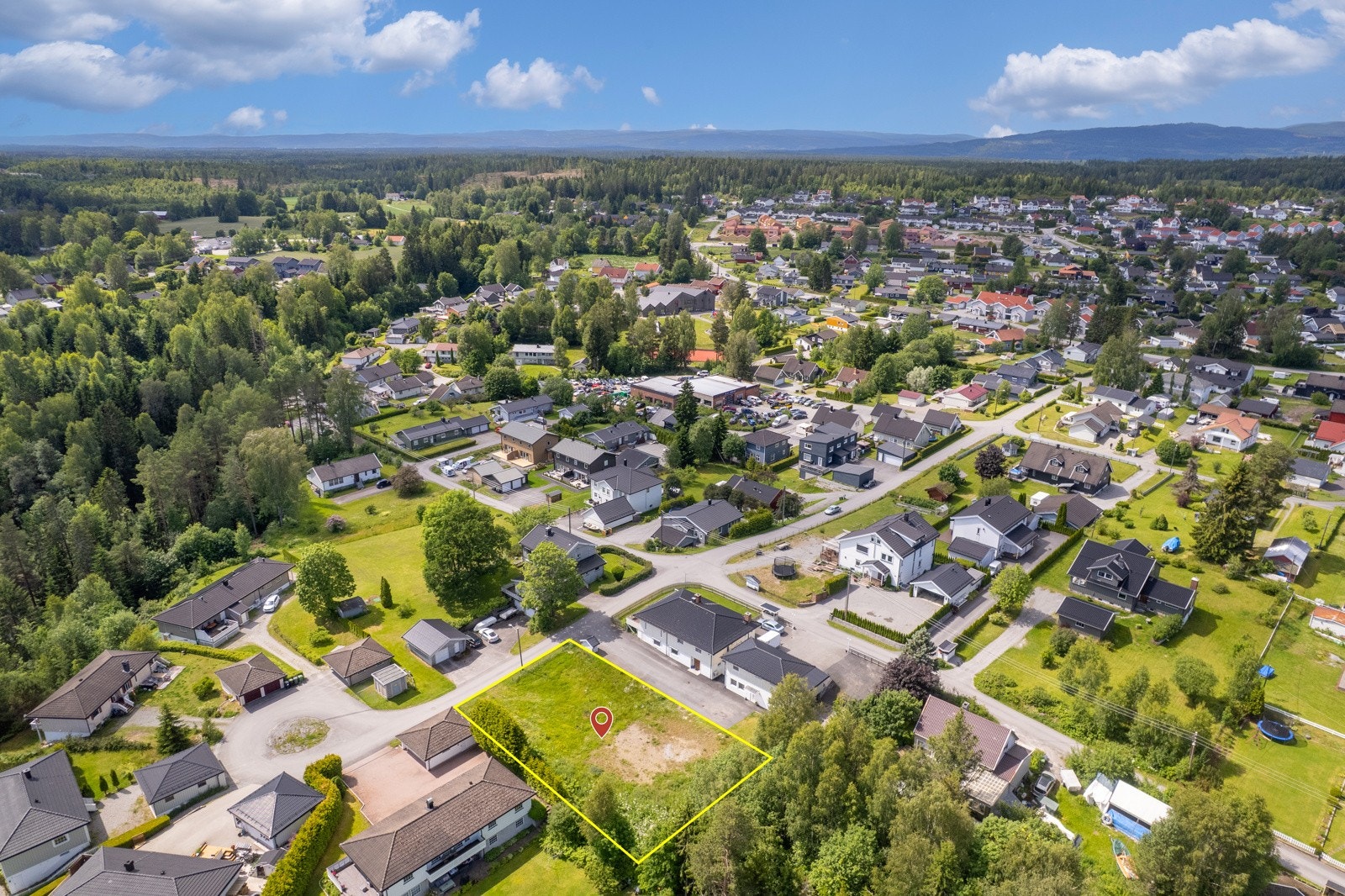 Dronebilde over nærområdet. Det gjøres særskilt oppmerksom på at tomten selges alene uten noen form for byggeklausul. NB! Skissert omrisse av eiendommen er kun veiledende, se situasjonskart. Galleribilde