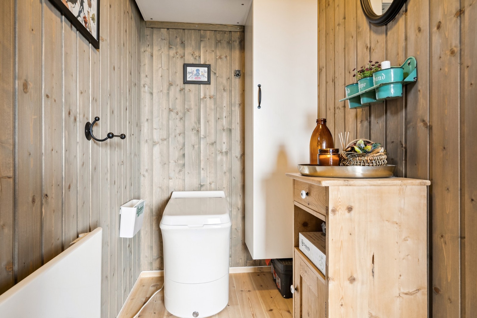 Toalettrom på 2,6 kvm med forbrenningstoalett, lufting over tak og vegghengt panelovn. Galleribilde