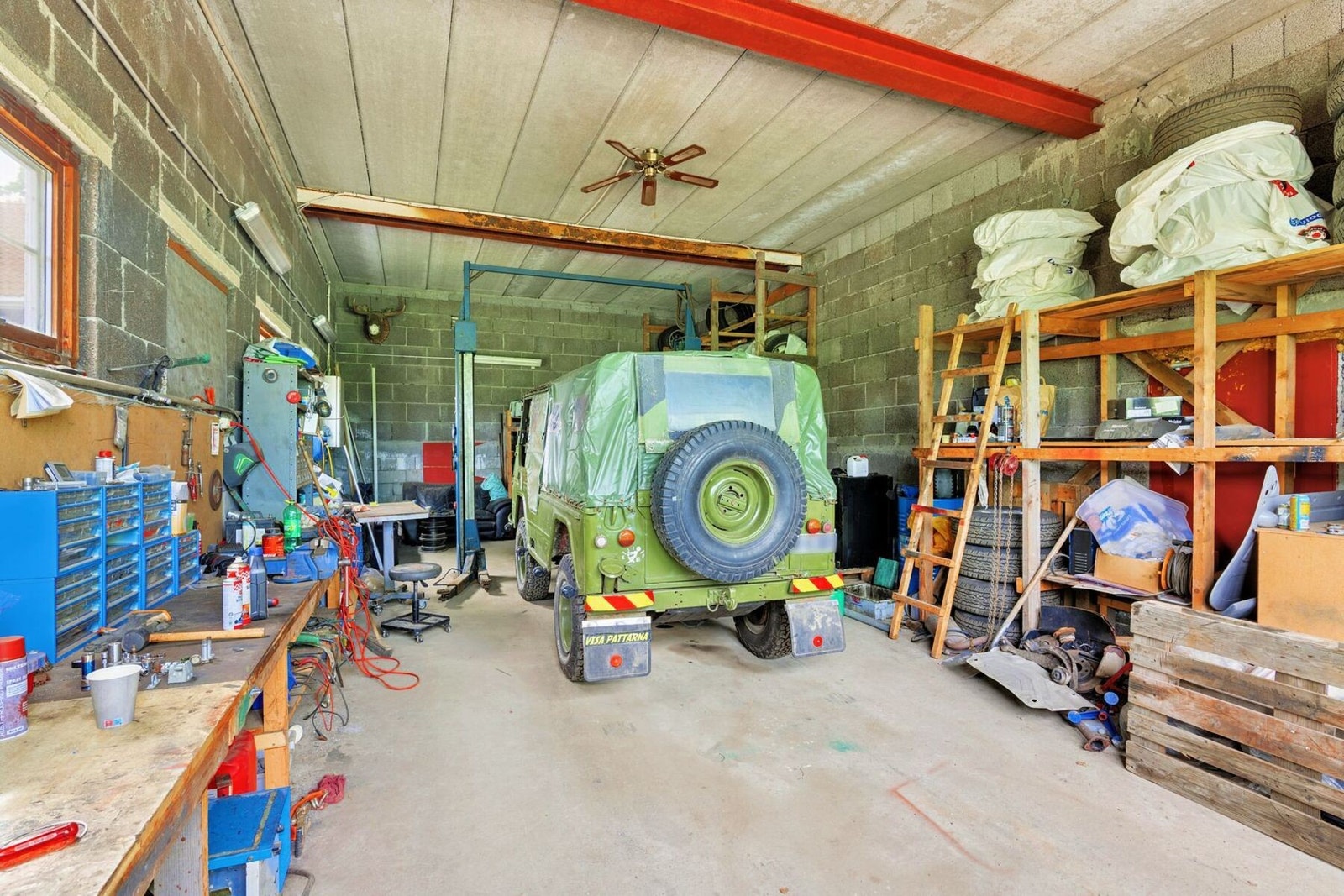 Praktisk garasje med løftebukk og innredning som passer perfekt for hobby-mekanikeren og bilentusiasten Galleribilde