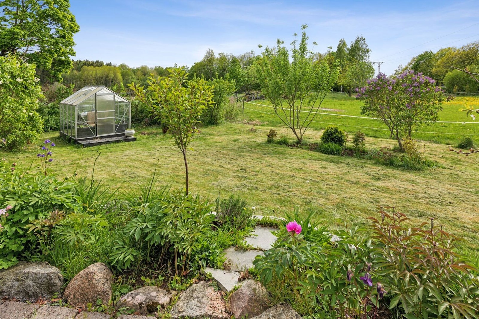 Hagen er pent opparbeidet og har et drivhus som gir mulighet for dyrking gjennom store deler av året Galleribilde
