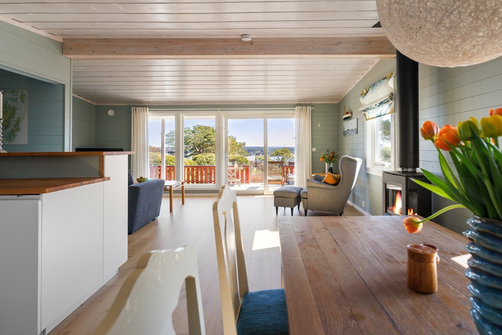 Det er store vinduer og skyvedør i stuen som gjør at naturen kommer inn i hytta. Galleribilde