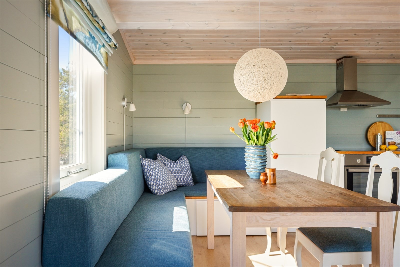 I tilknytning til kjøkkenet er det et spisebord og en snekkerbygd sofa med oppbevaring. Galleribilde