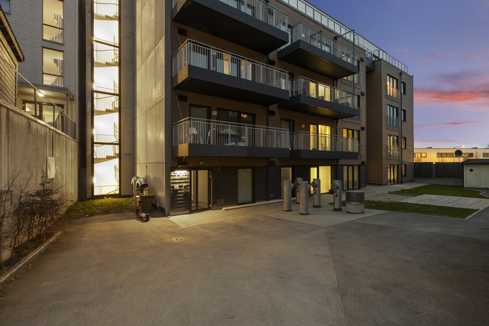 Bygningens fasade med balkonger og felles uteområde. Galleribilde