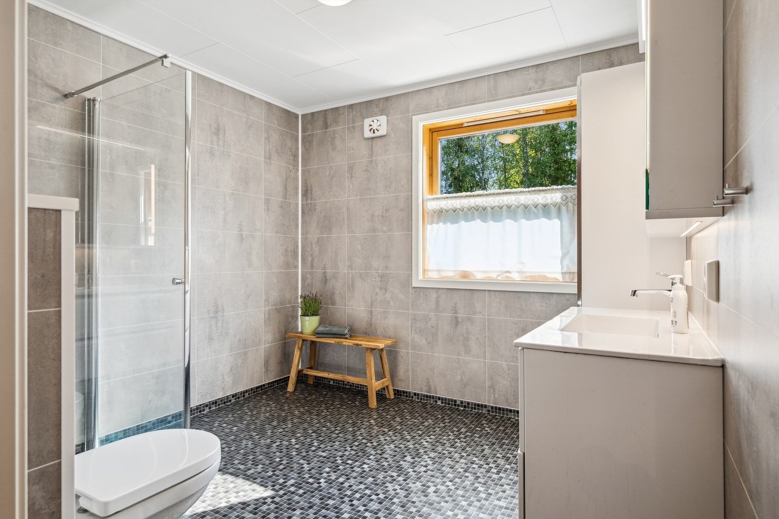 Badet i 1. etasje ble renovert i 2019 med bl.a. baderomsplater på vegger og vinylbelegg på gulv. Galleribilde