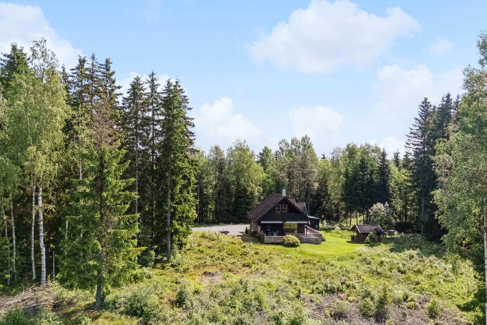 Som man ser ligger eiendommen idyllisk til med naturlig vegetasjon i ytterkant, innrammet av skog på flere sider og åpent landskap mot vest. Galleribilde