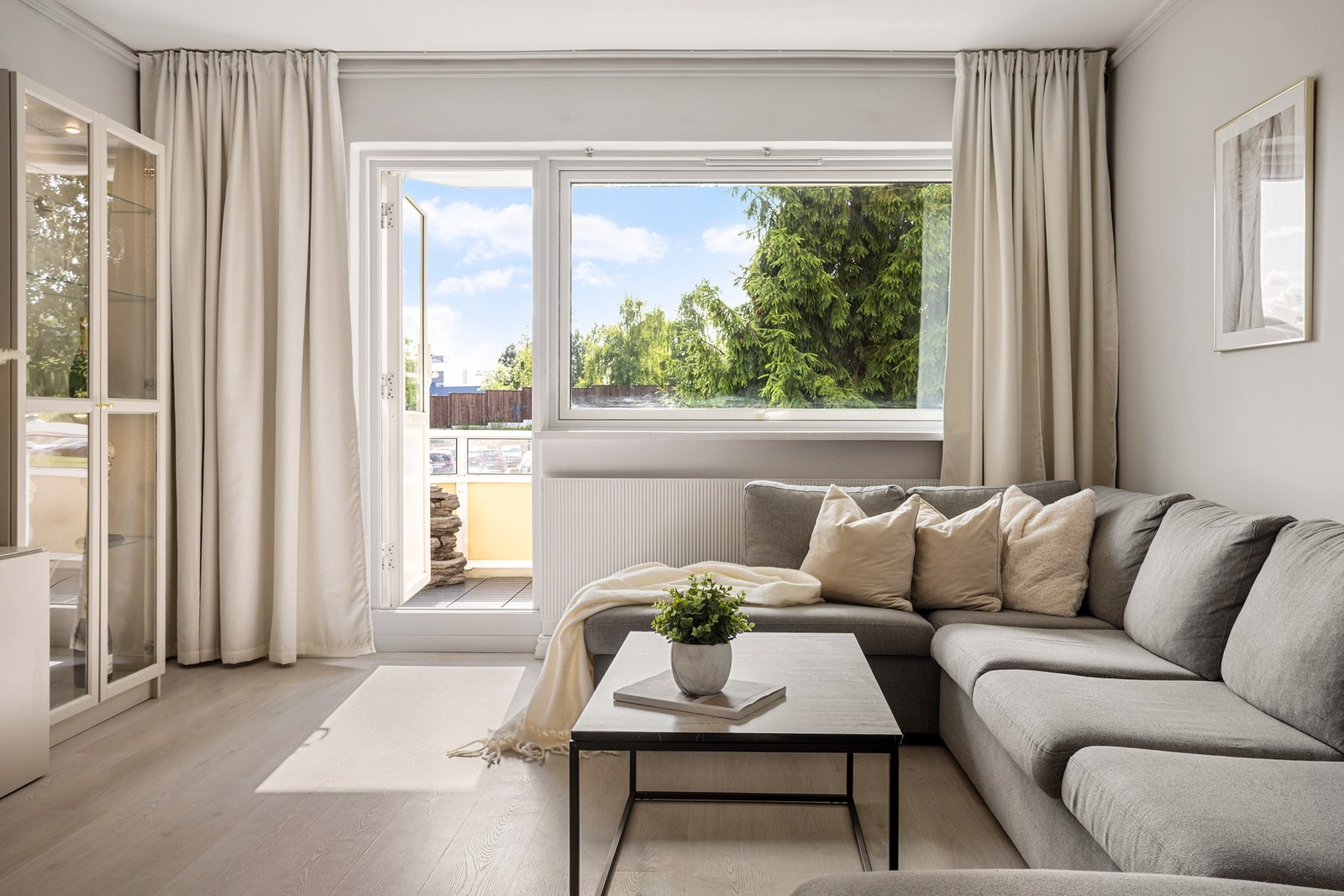 Fra stuen er det utgang til boligens herlige balkong. Hyggelig utsyn mot frodige omgivelser, i tillegg til at den høye beliggenheten, ingen boligbygg foran og trærne gjør at det blir lite innsyn. Galleribilde