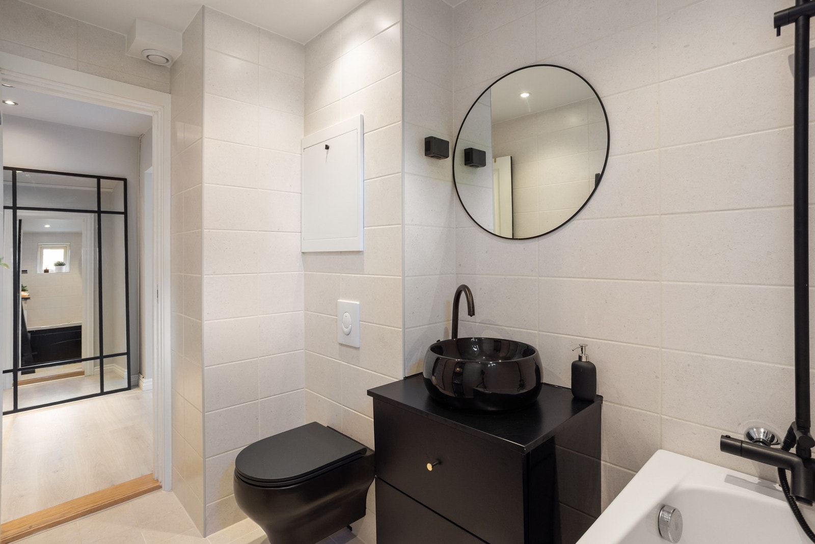 Boligens baderom er bygget opp med delikate fliser på gulv og vegger, downlights og gulvvarme. Galleribilde