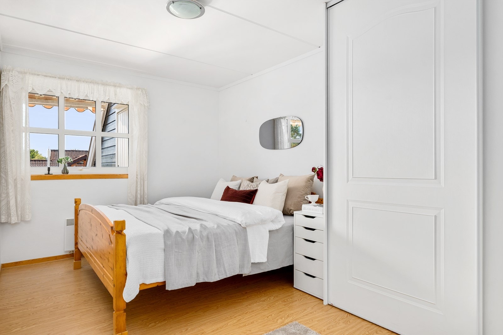 Langs den ene veggen er det etablert en romslig skyvedørsgarderobe med god oppbevaringsplass for klær, sko og tilbehør. Skyvedørene sørger for en plassbesparende og stilren løsning som holder rommet ryddig og oversiktlig. Galleribilde