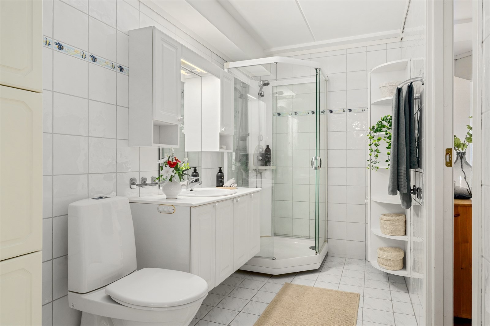 Baderommet fremstår som praktisk og innbydende, med flislagte vegger og gulv som gir et rent og tidløst uttrykk. Galleribilde