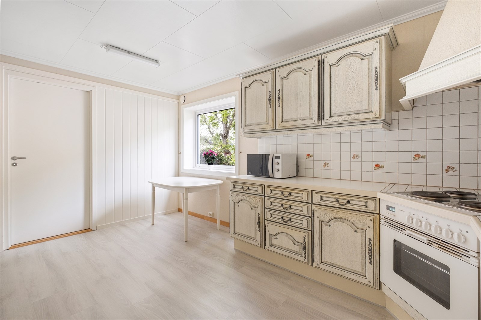 Lyst kjøkken med god plass til spisegruppe Galleribilde