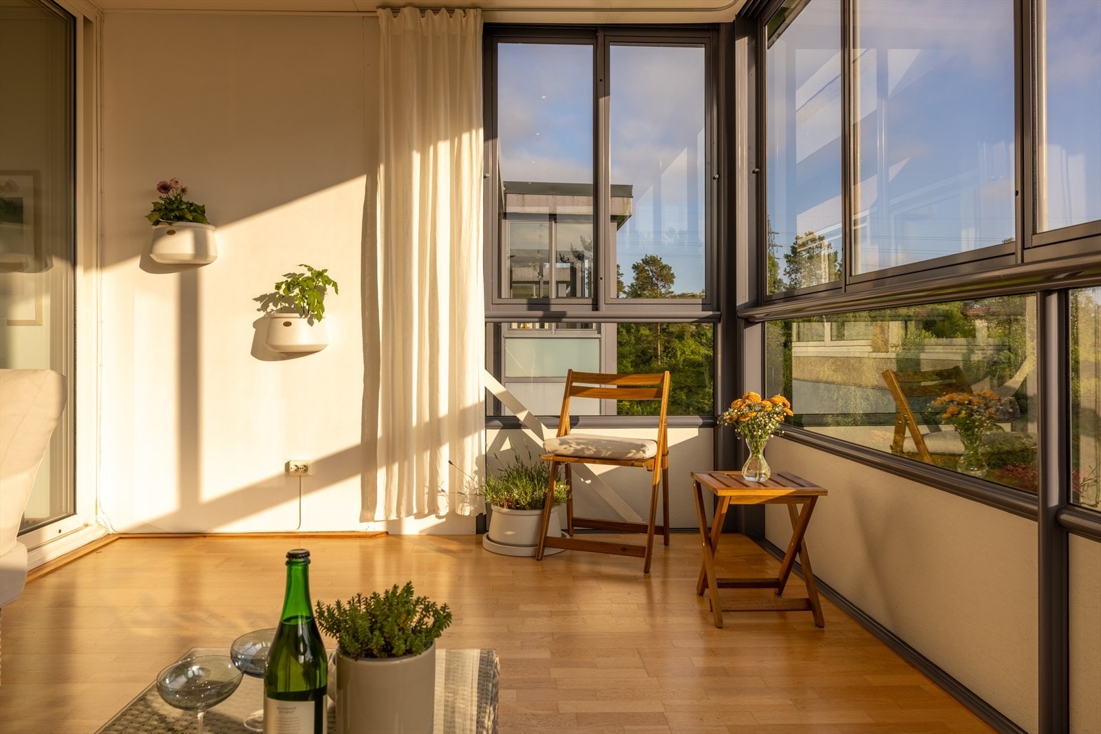 Den 12 m² store, innglassede balkongen fungerer som en lun hagestue med panoramautsikt. Galleribilde