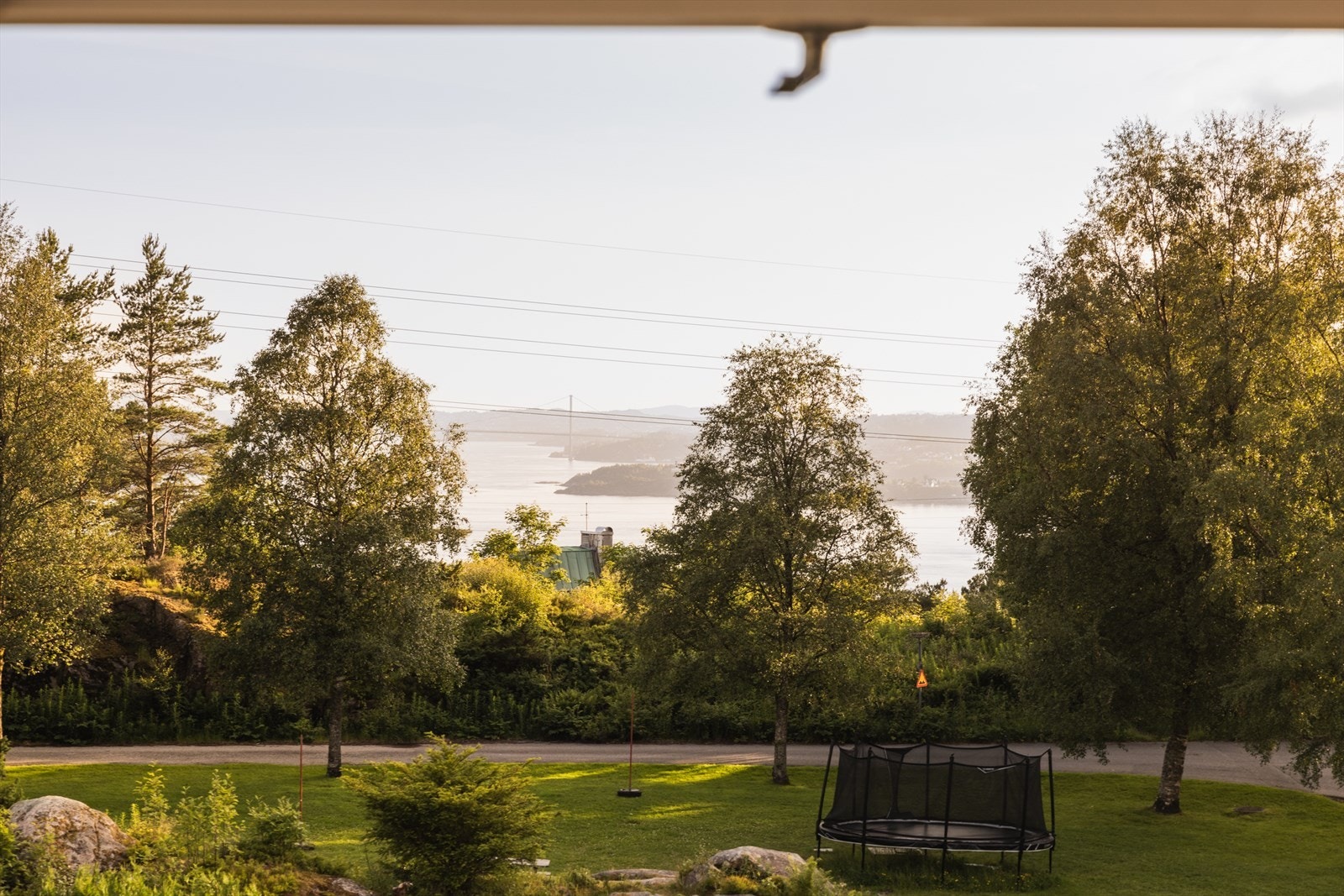 Fra det ene soverommet har du nydelig utsikt mot Byfjorden og fjellene i vest. Her får du et vakkert blikkfang rett fra sengekanten - med kveldssol og en åpen horisont. Galleribilde