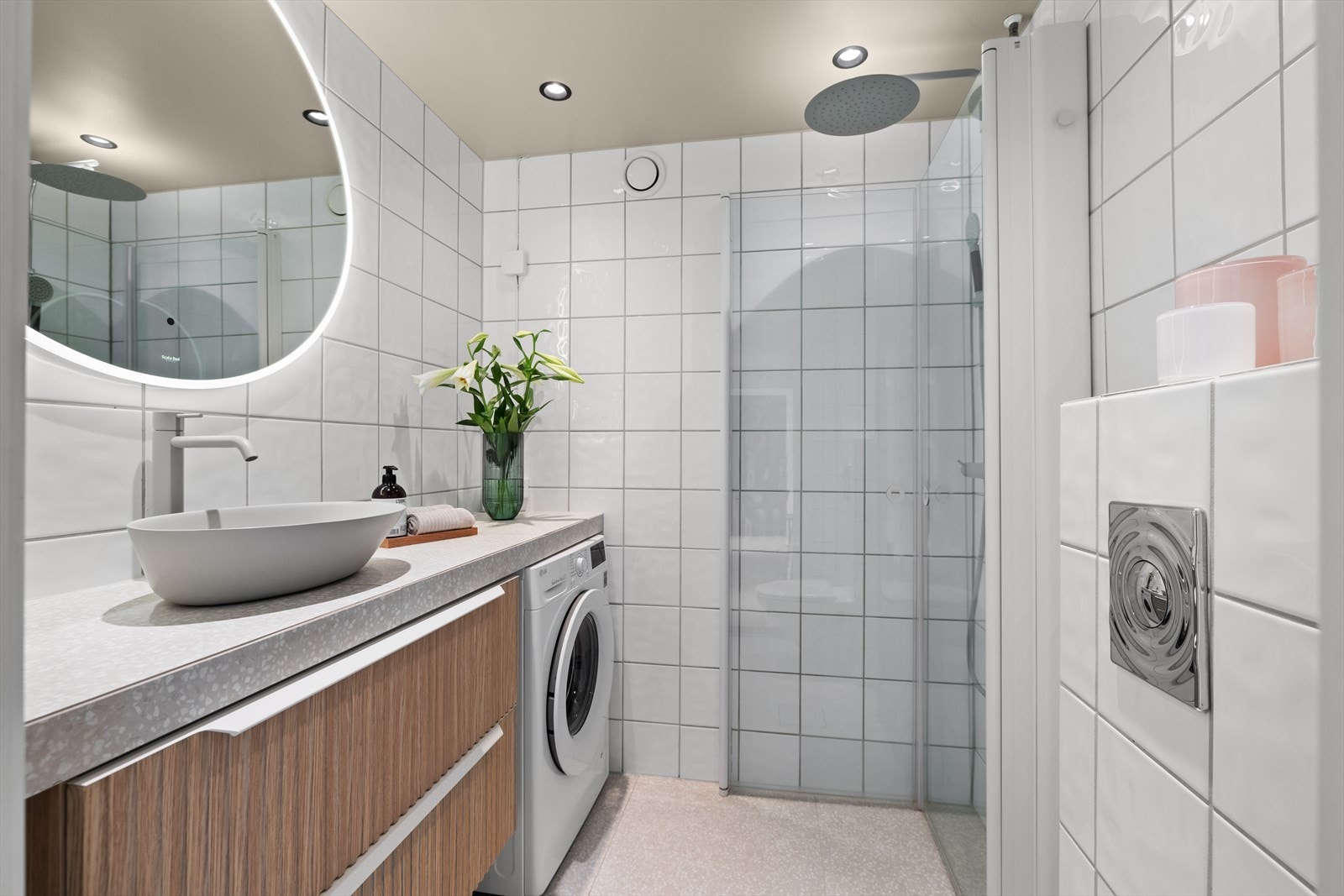 Innredet med vegghengt klosett, servant plassert på benkeplate, speil m/lys og dusjhjørne med svingbare glassdører. Galleribilde