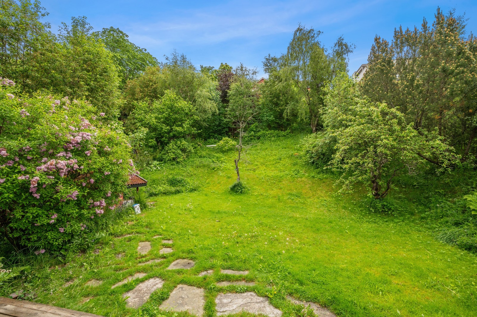 Boligen byr på en idyllisk hage på baksiden. Galleribilde