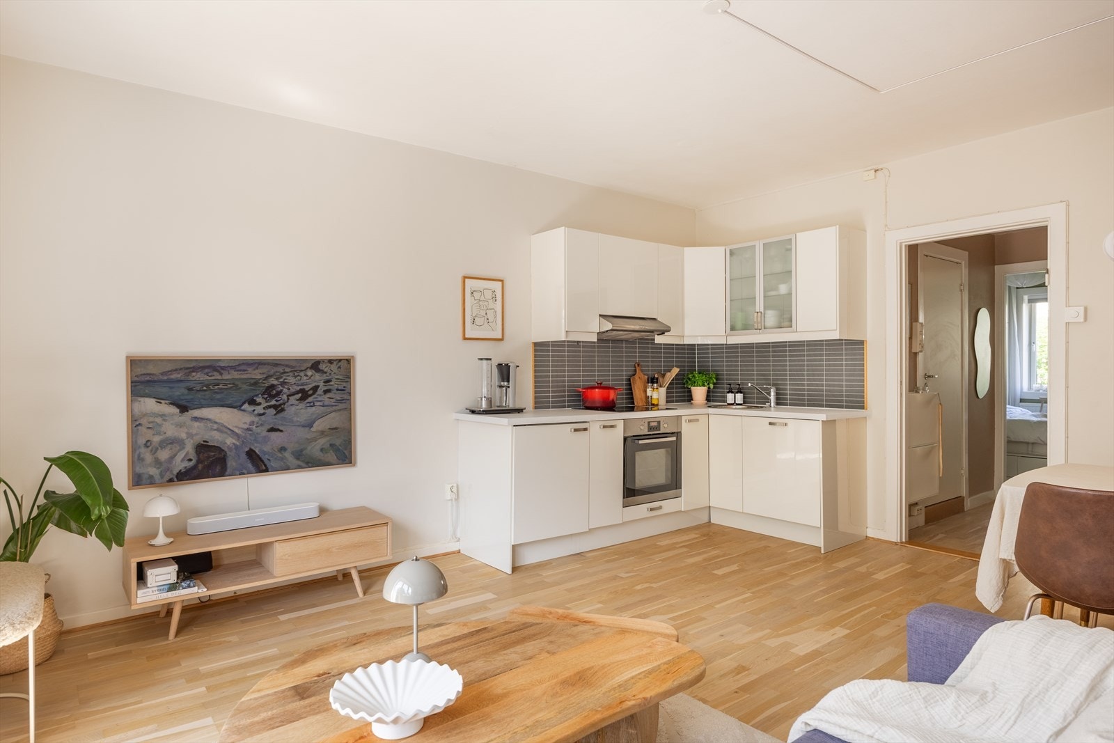 Kjøkkeninnredning fra 2010 med fronter i høyglanset utførelse, to frostede glassfronter i overskap og lyslister og belysning under overskap Galleribilde