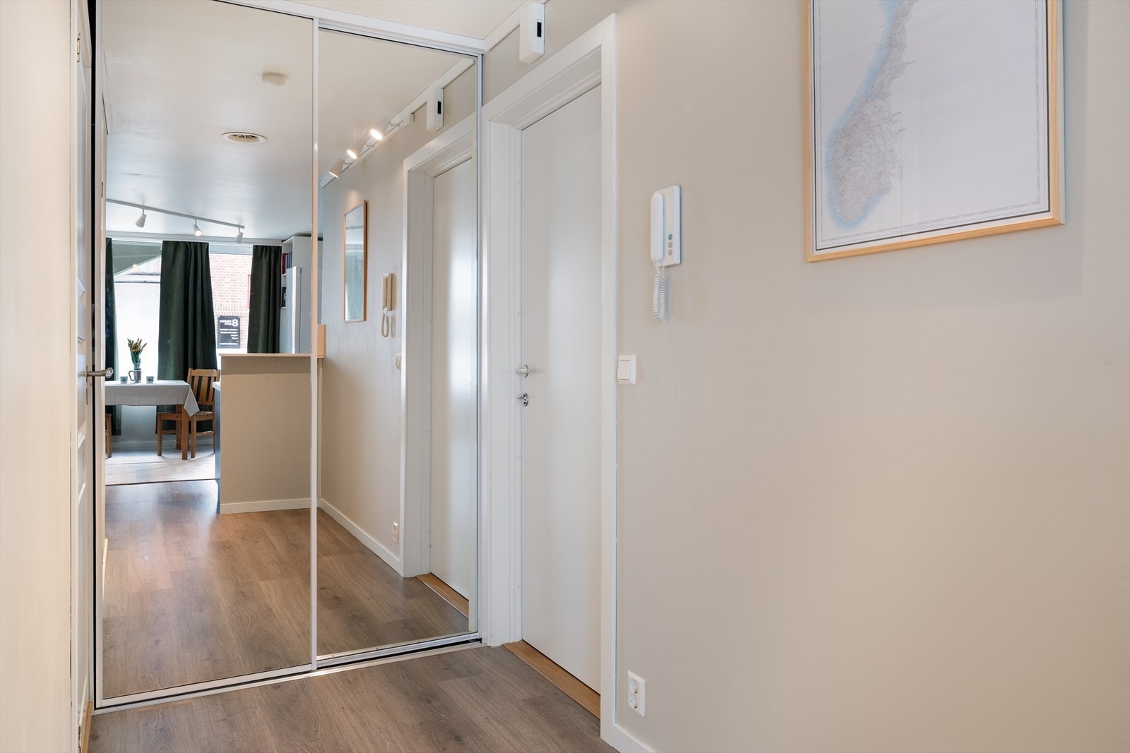 Det første som møter deg i leiligheten er en lys og innbydende entré. Her er det innredet med en praktisk skyvedørsgarderobe med helspeil. Galleribilde