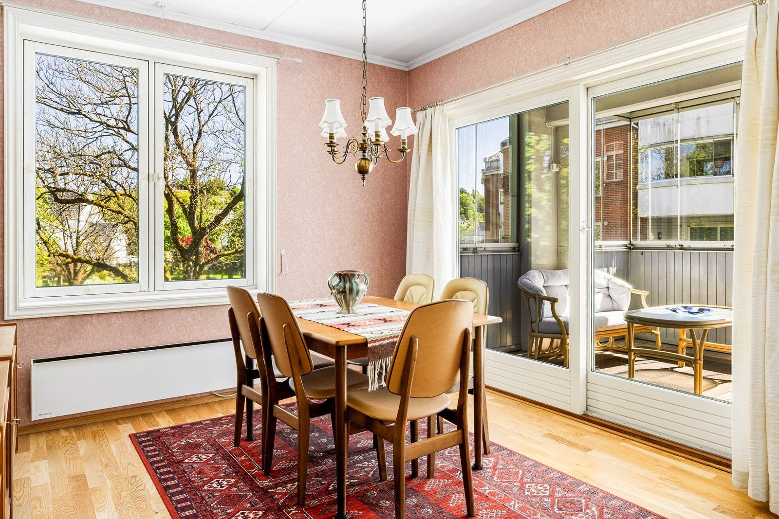 Spiseplassen ligger lyst og trivelig til som en naturlig forlengelse av stuen, med store vindusflater som slipper inn rikelig med dagslys og gir en fin forbindelse mellom inne og ute. Galleribilde
