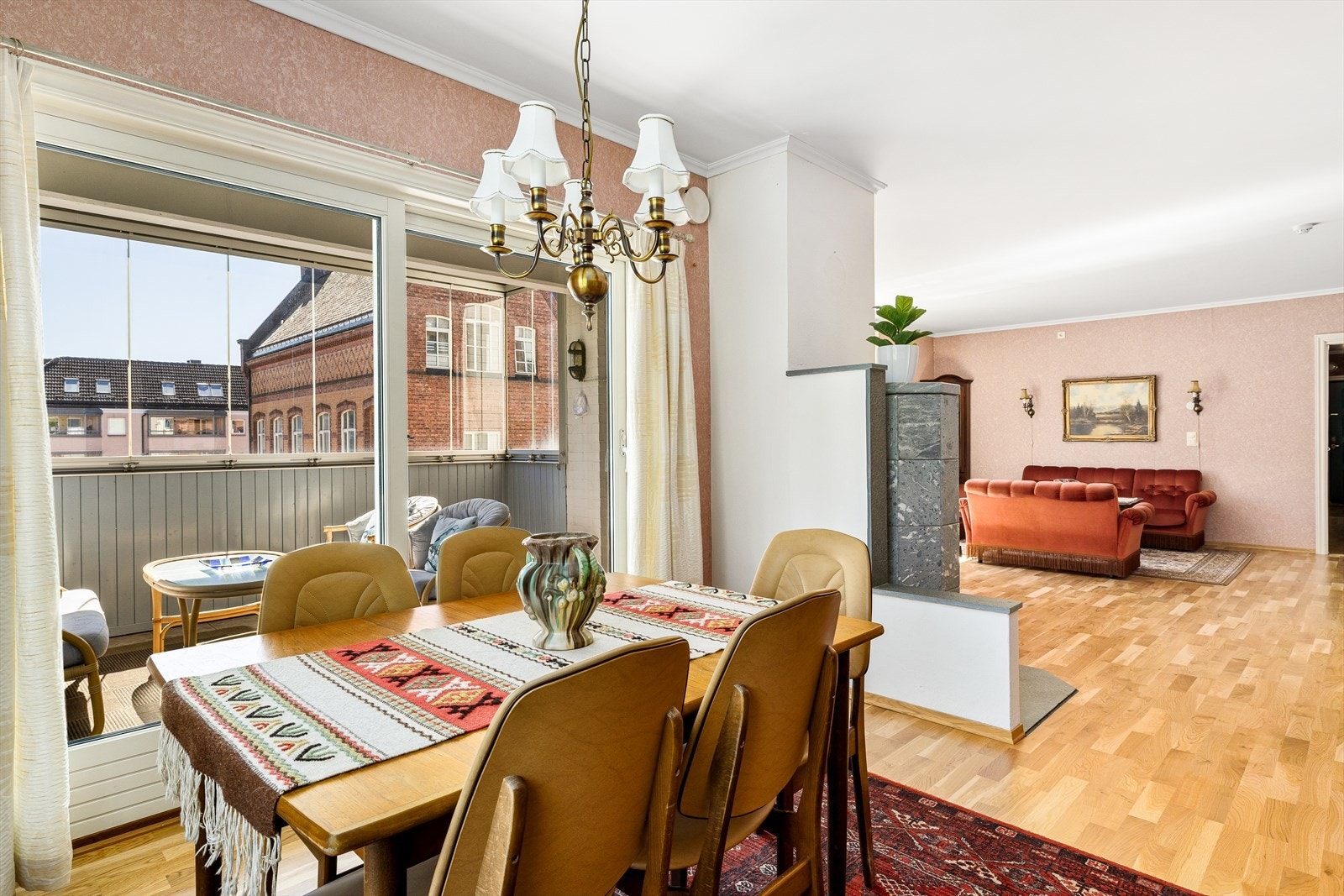 Rommet føles både åpent og skjermet på samme tid - perfekt for lange helgefrokoster, middager med familie og venner, eller en stille kopp kaffe mens du ser ut på byens liv. Plasseringen er gjennomtenkt, og gir god avstand til både stue og kjøkken. Galleribilde