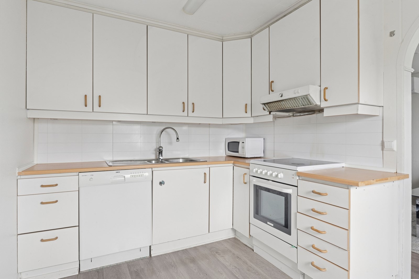 Kjøkkenet ligger i tilknytting til stuen og har godt med skapplass og benkeplass (L3) Galleribilde