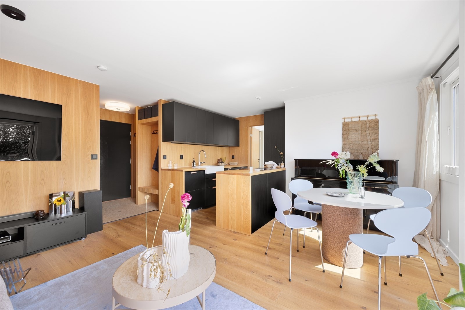 Lekkert kjøkken i sort med spesialtilpassede løsninger i eik. Galleribilde