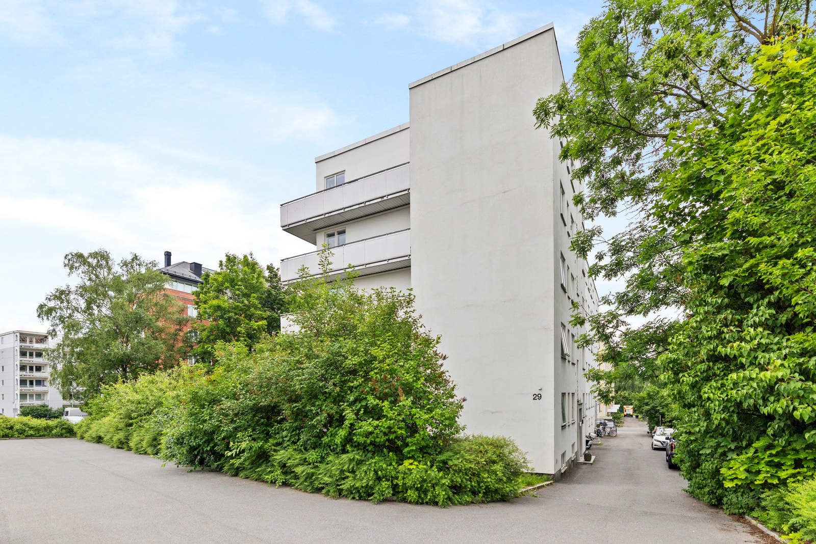 Bygningen er omgitt av grønne busker og trær. En rolig og grønn oase rundt eiendommen Galleribilde